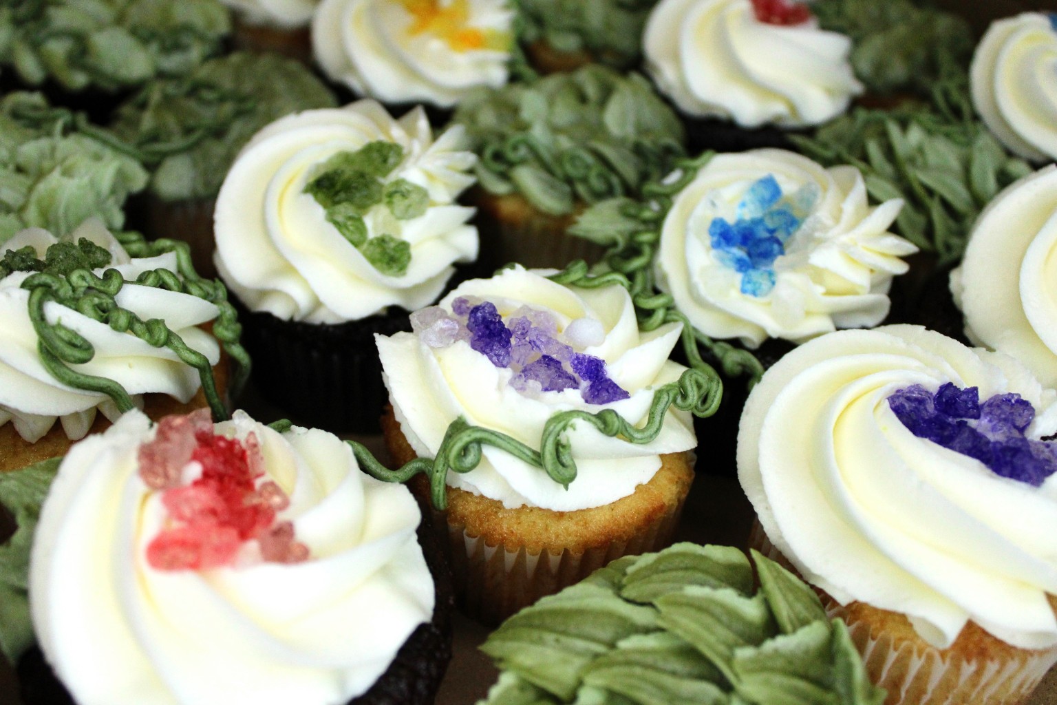 Decorated cupcakes with white frosting and colorful sugar crystals