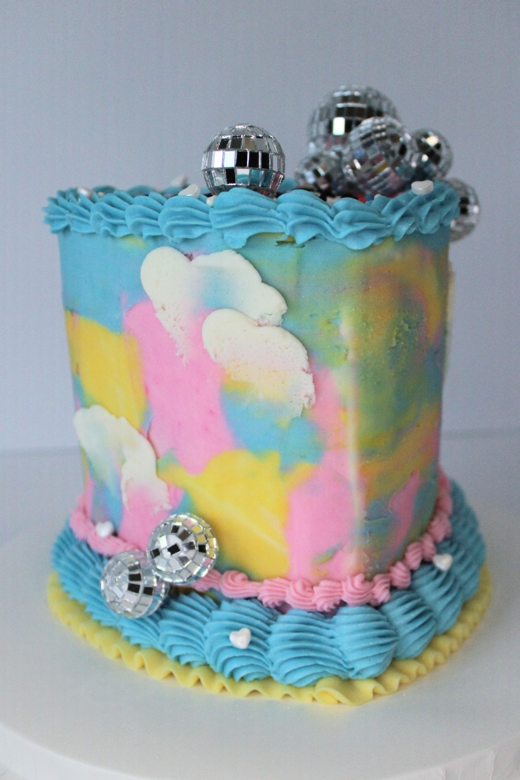 Pastel custom cake decorated with clouds and disco balls